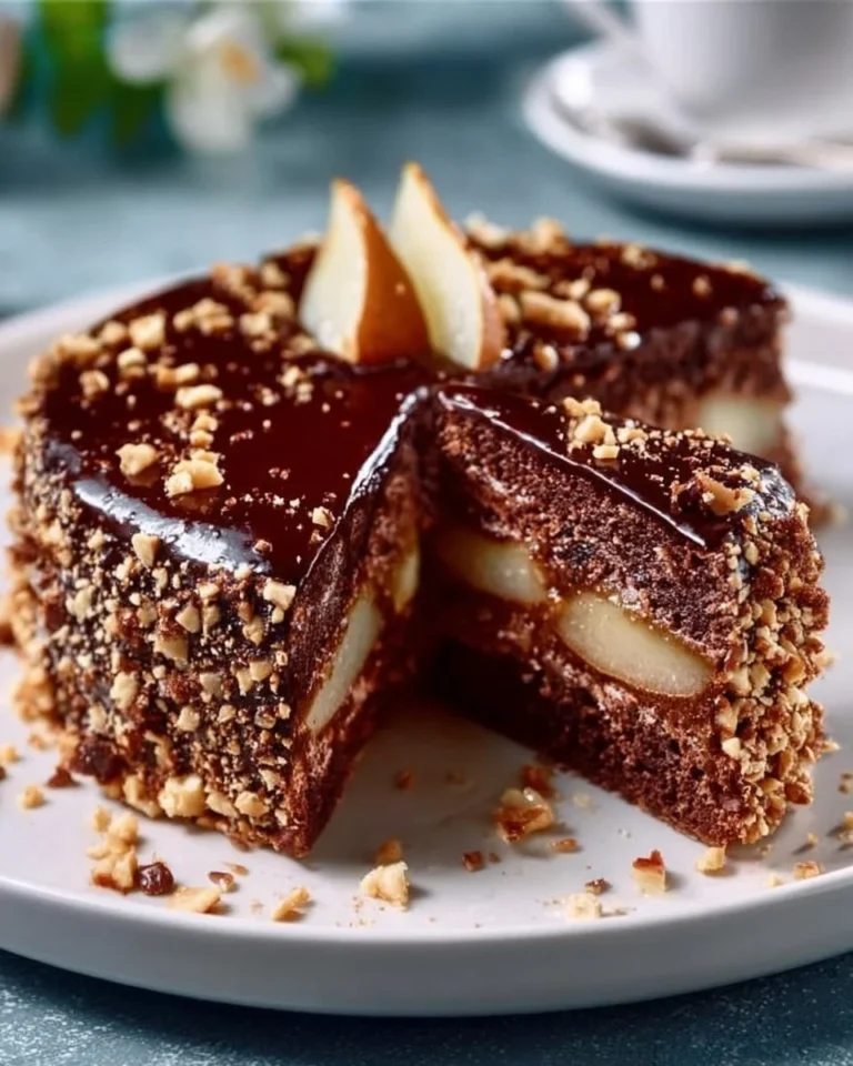 Delicious Chocolate Pear Cake topped with fresh pear slices and chocolate drizzle