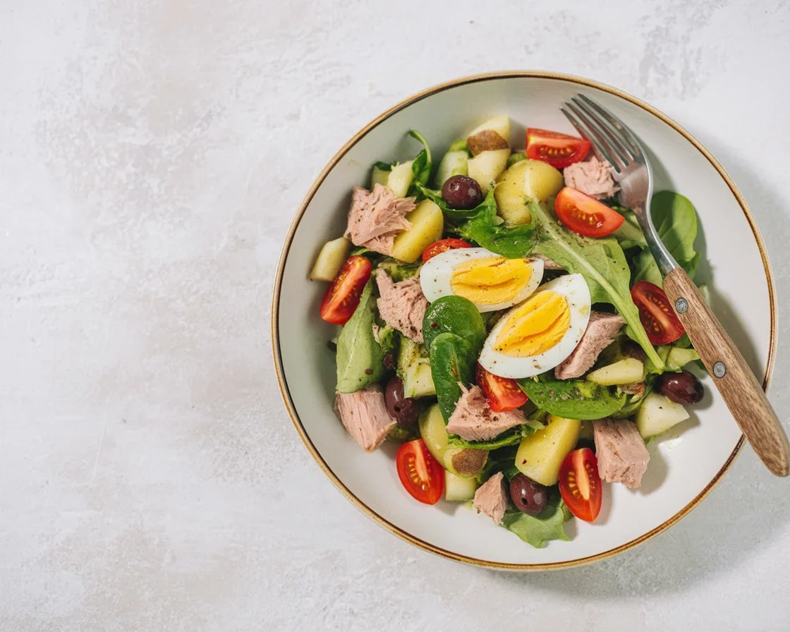 Salade niçoise avec tomates, œufs durs, thon, olives et huile d'olive